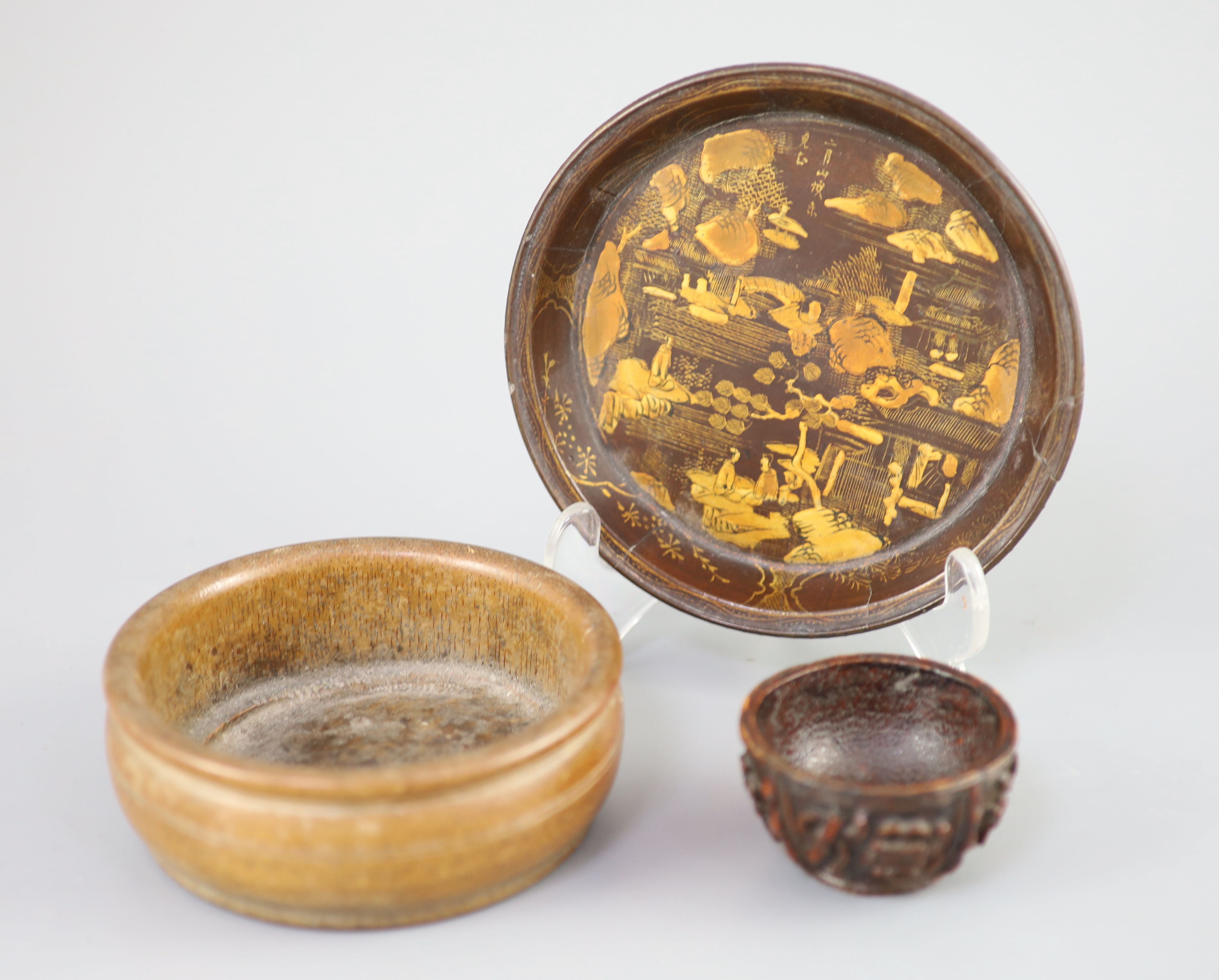 A Chinese carved bamboo cup, a plain bamboo brushwasher, 18th/19th century and a gilt decorated lacquer saucer dish, 17th century,